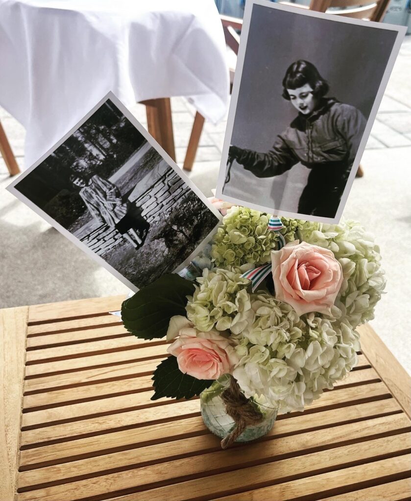 Floral arrangement with black and white portrait photo of a woman displayed in the blooms