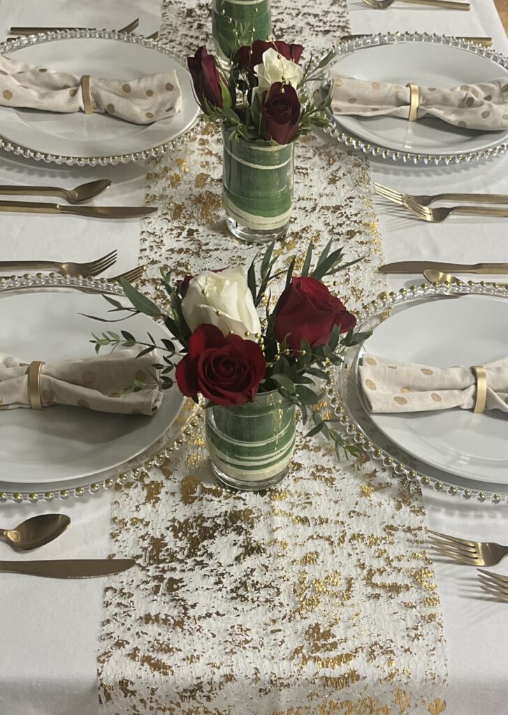 Elegant table setting with red rose centrepieces and textured lace runner