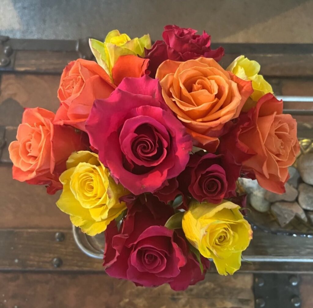 Overhead view of vibrant rose bouquet in yellow, orange, and fuchsia
