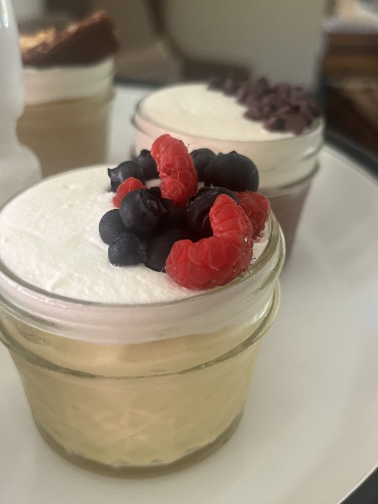 Mason jar cheesecake topped with fresh raspberries and blueberries